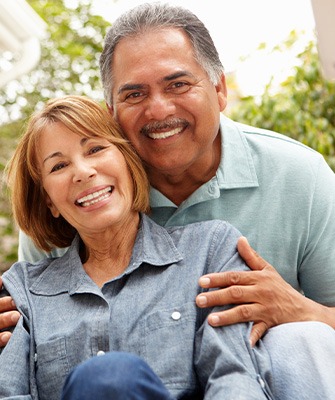 smiling older couple outside a white building