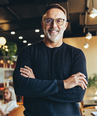 smiling man with arms folded in a business setting