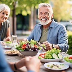 group of smiling older people gathered to eat