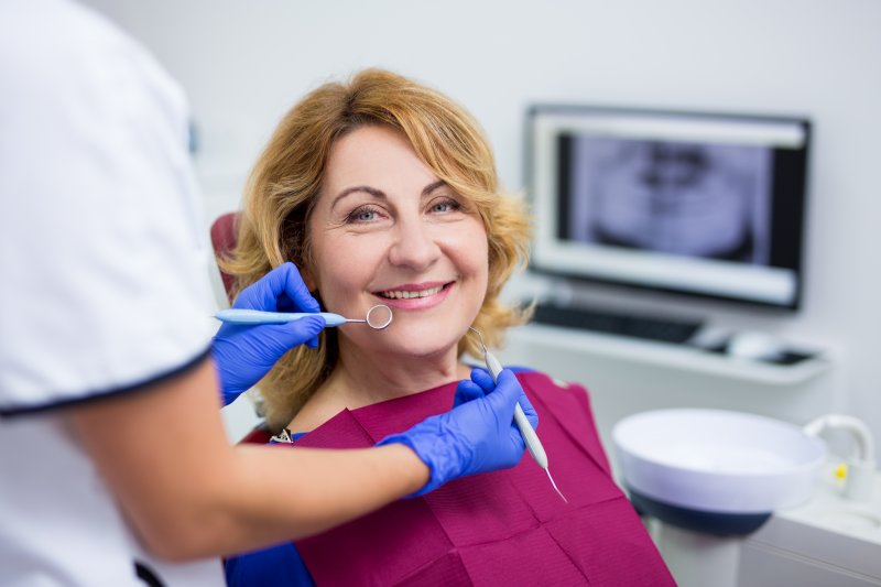 older patient smiling with the dentist next to her