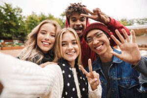 group of smiling teens taking a selfie