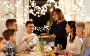 smiling family about to eat a holiday dinner together at the table